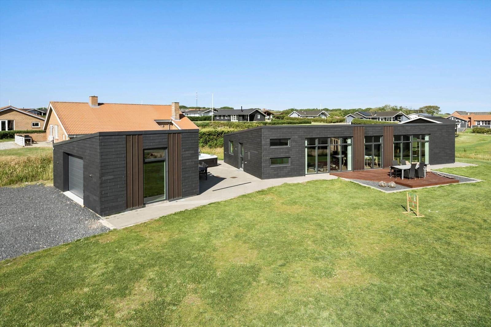 Moderne Villa mit großem Garten und Terrasse. Garage und großzügige Fensterfront.