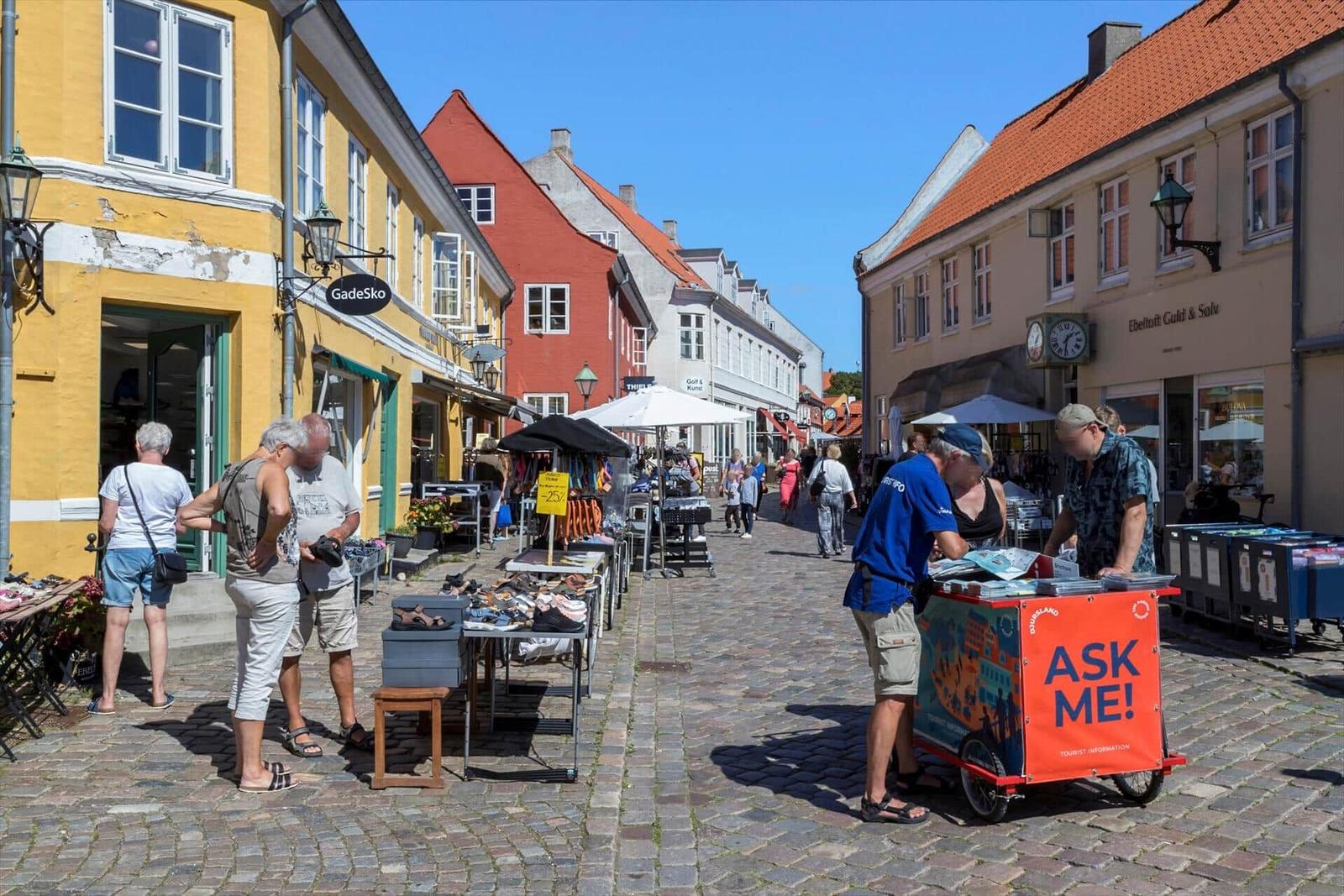 Street with shop fronts and tourist information.