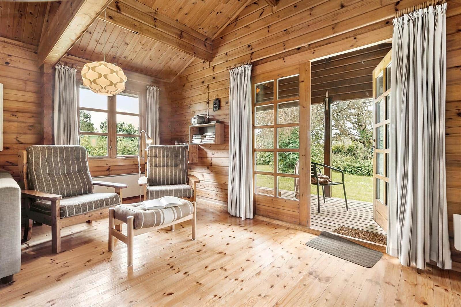 Wood-paneled room with seating and view to the terrace.