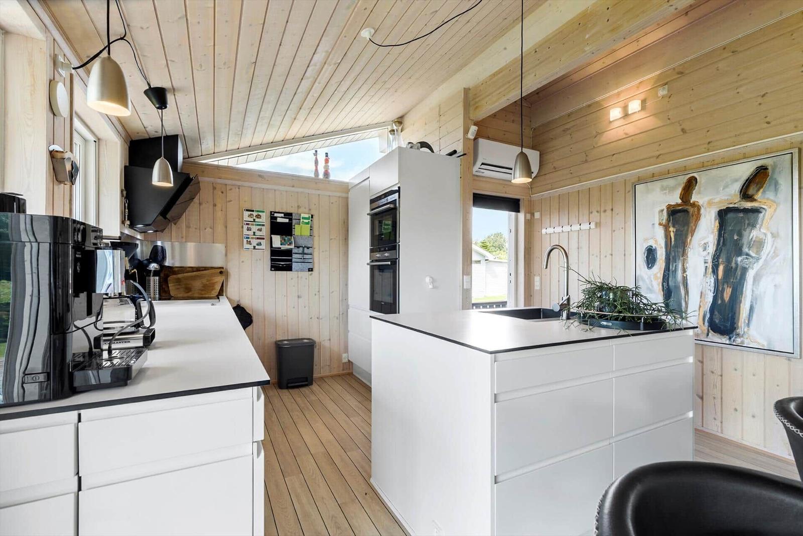 Moderne Küche mit Holzwänden, weißer Arbeitsfläche und integriertem Herd.