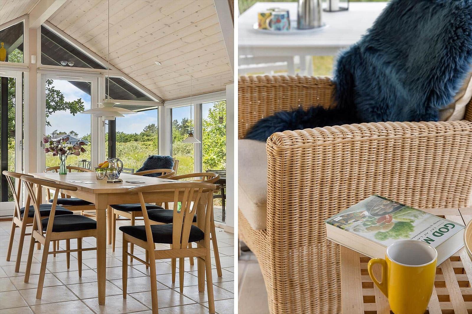 Essbereich mit Holztisch und Stühlen. Außenterrasse mit Rattanmöbeln und Buch.