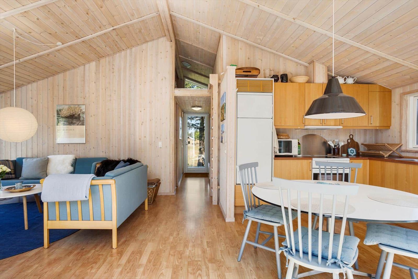 Living and dining area with kitchen in wooden house