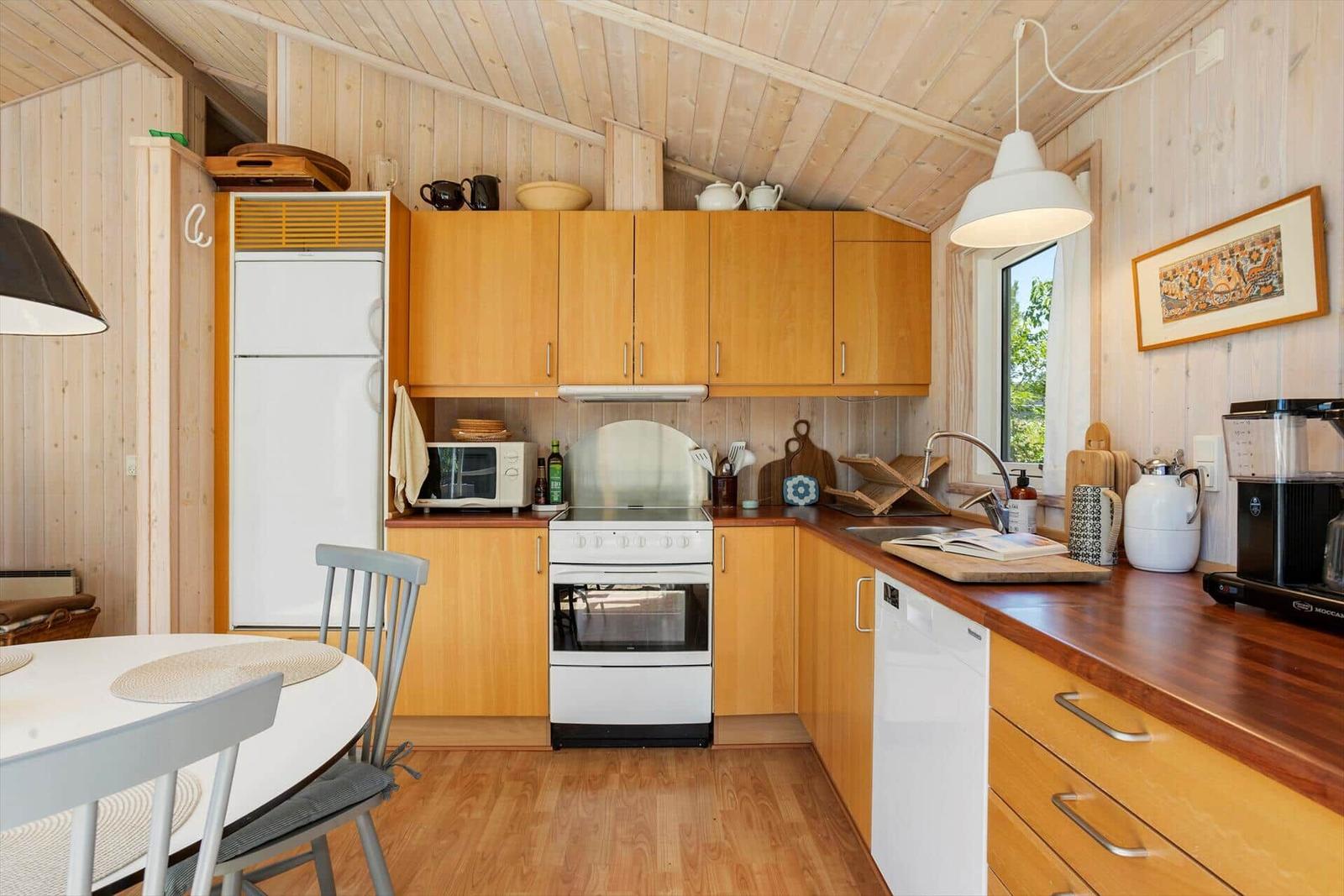 Kitchen with wooden walls, white appliances, and wooden countertops.