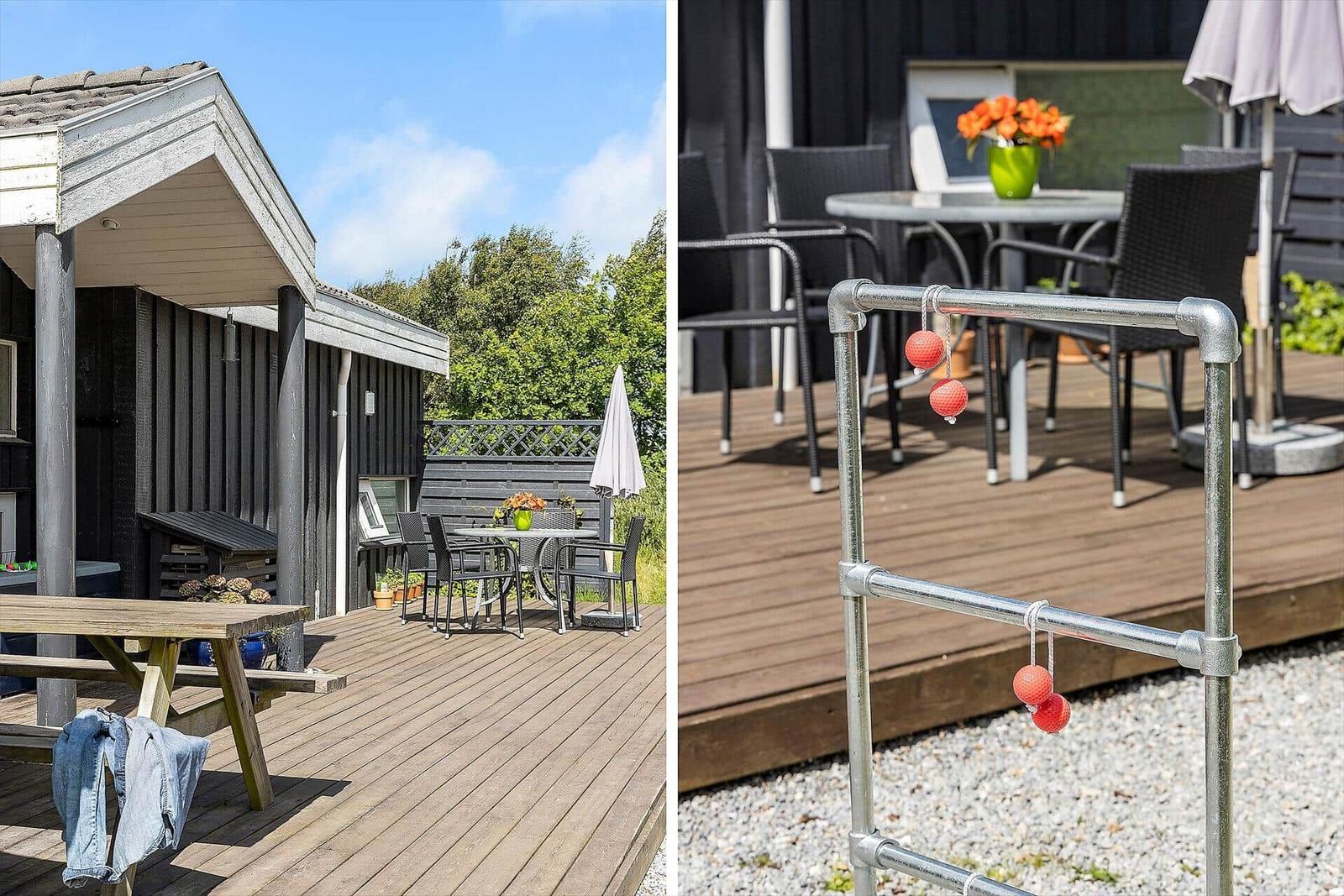 Terrasse mit Tisch, Stühlen und Picknicktisch. Spielgerät mit roten Bällen.