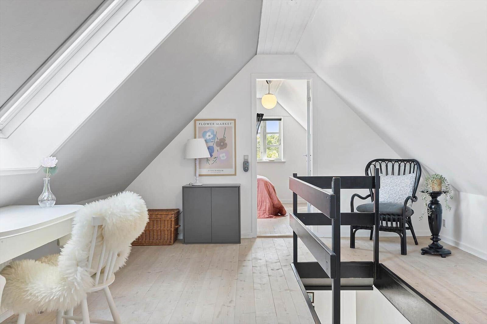 Dachgeschosszimmer mit Schreibtisch, Bett und Fenster