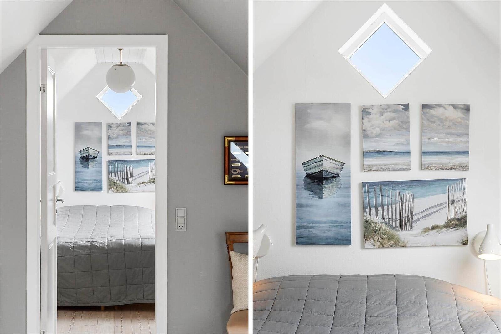 Schlafzimmer mit Dachfenster und Strandbildern an der Wand.