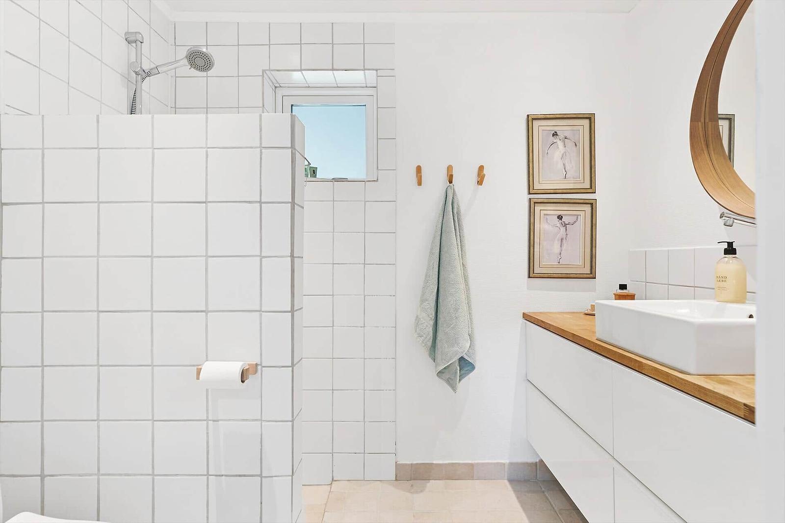 Badezimmer mit Dusche, Waschbecken und Spiegel.