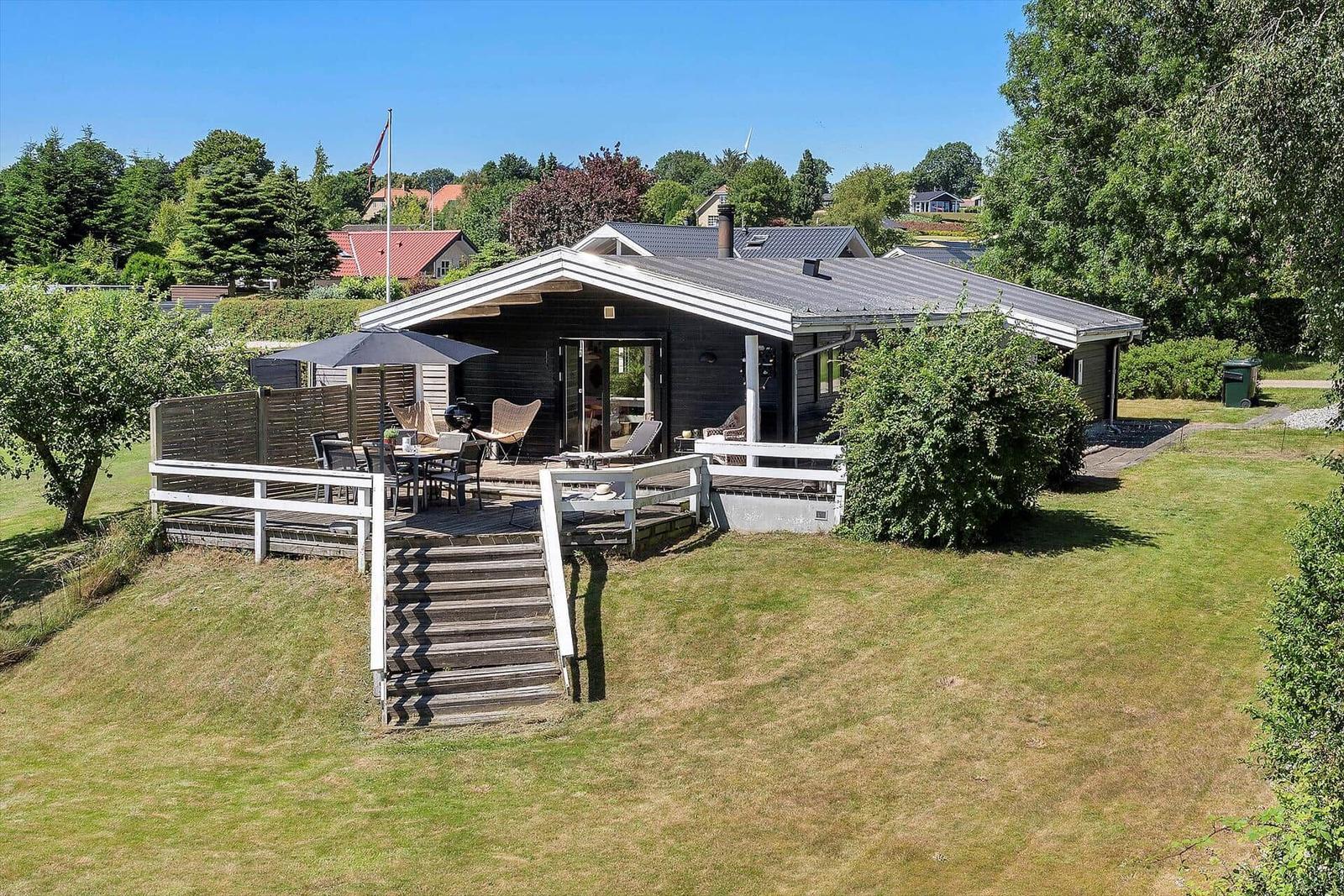House with terrace, grill, and seating in the garden.