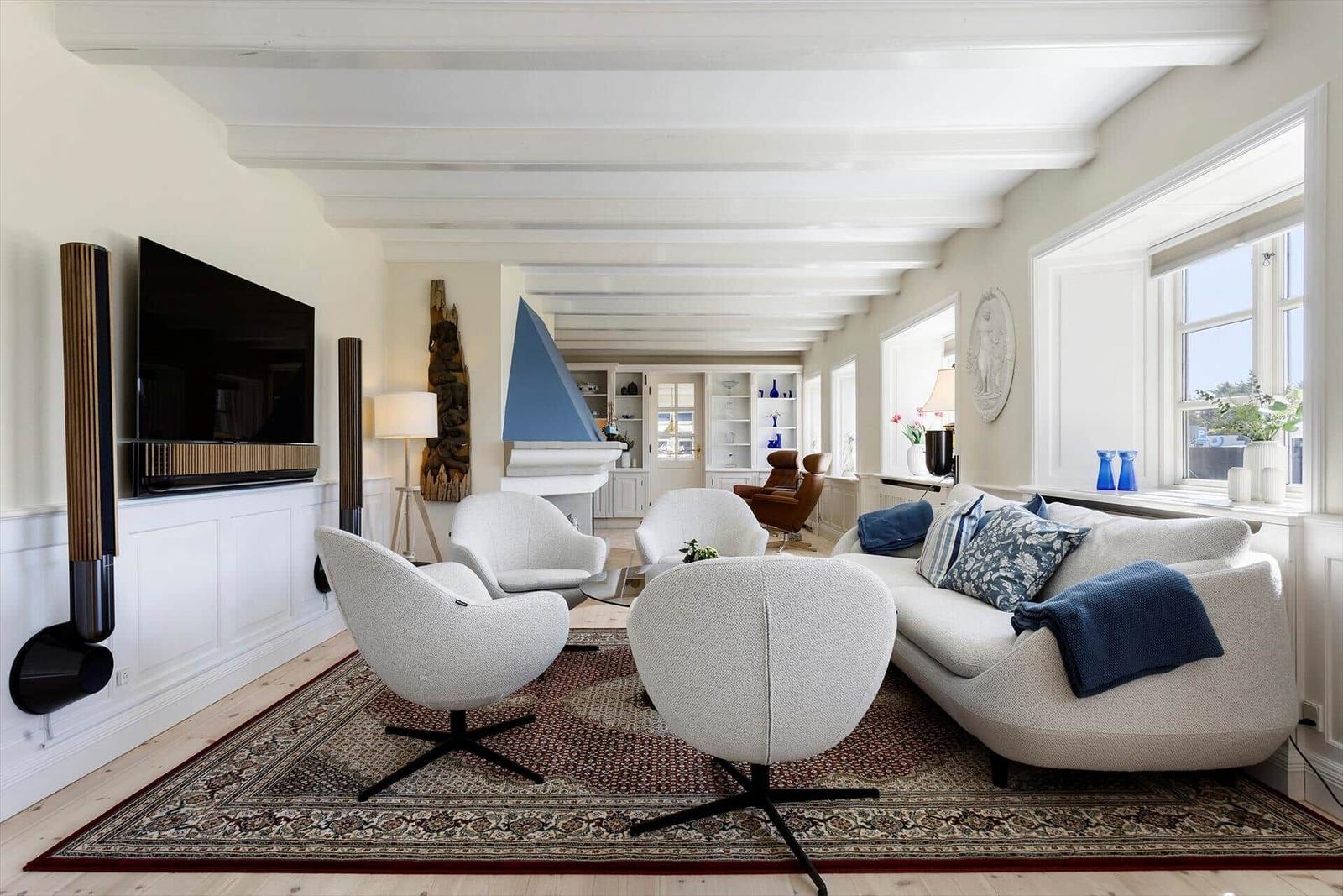 Living room with sofa, chairs, and TV mounted on wall.