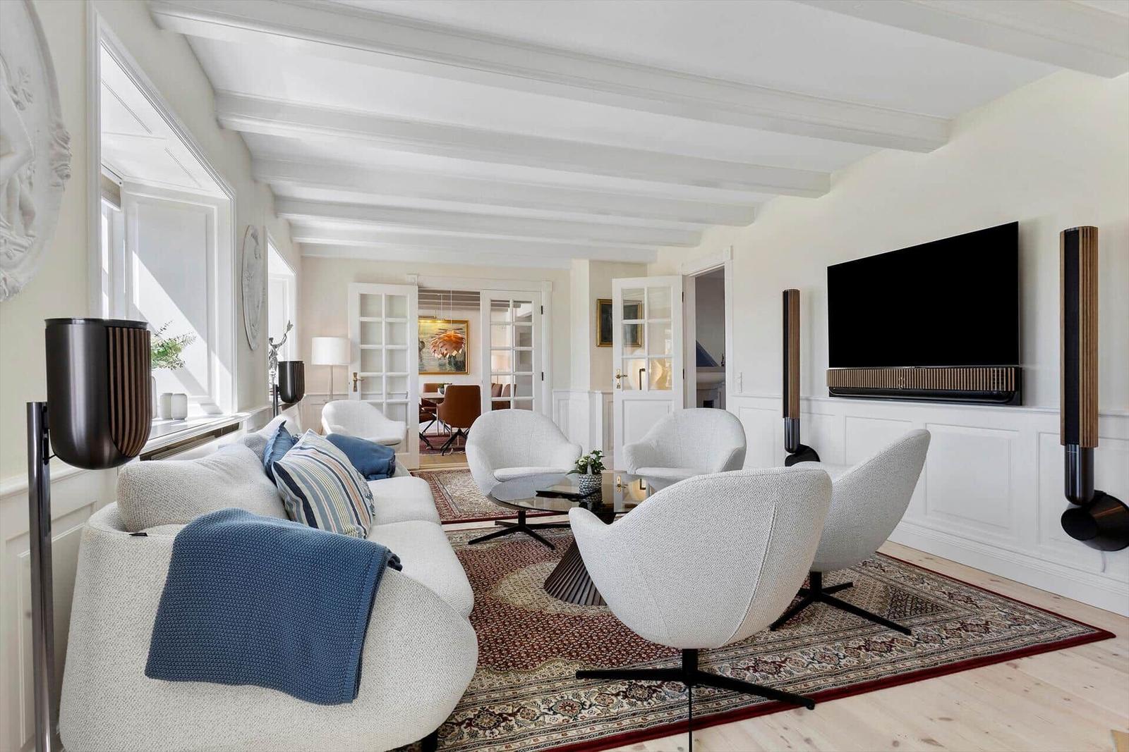Living room with sofa, chairs, and TV mounted on wall.