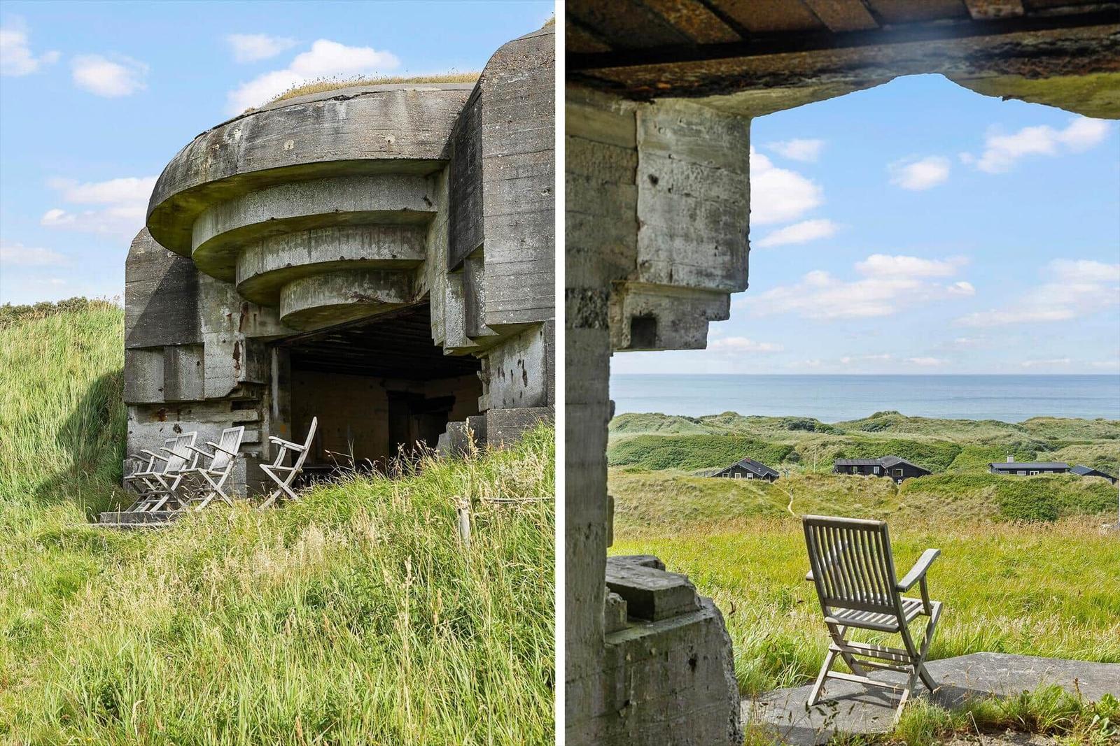 Old bunker structure with sea and grassland view. Wooden chairs outside.