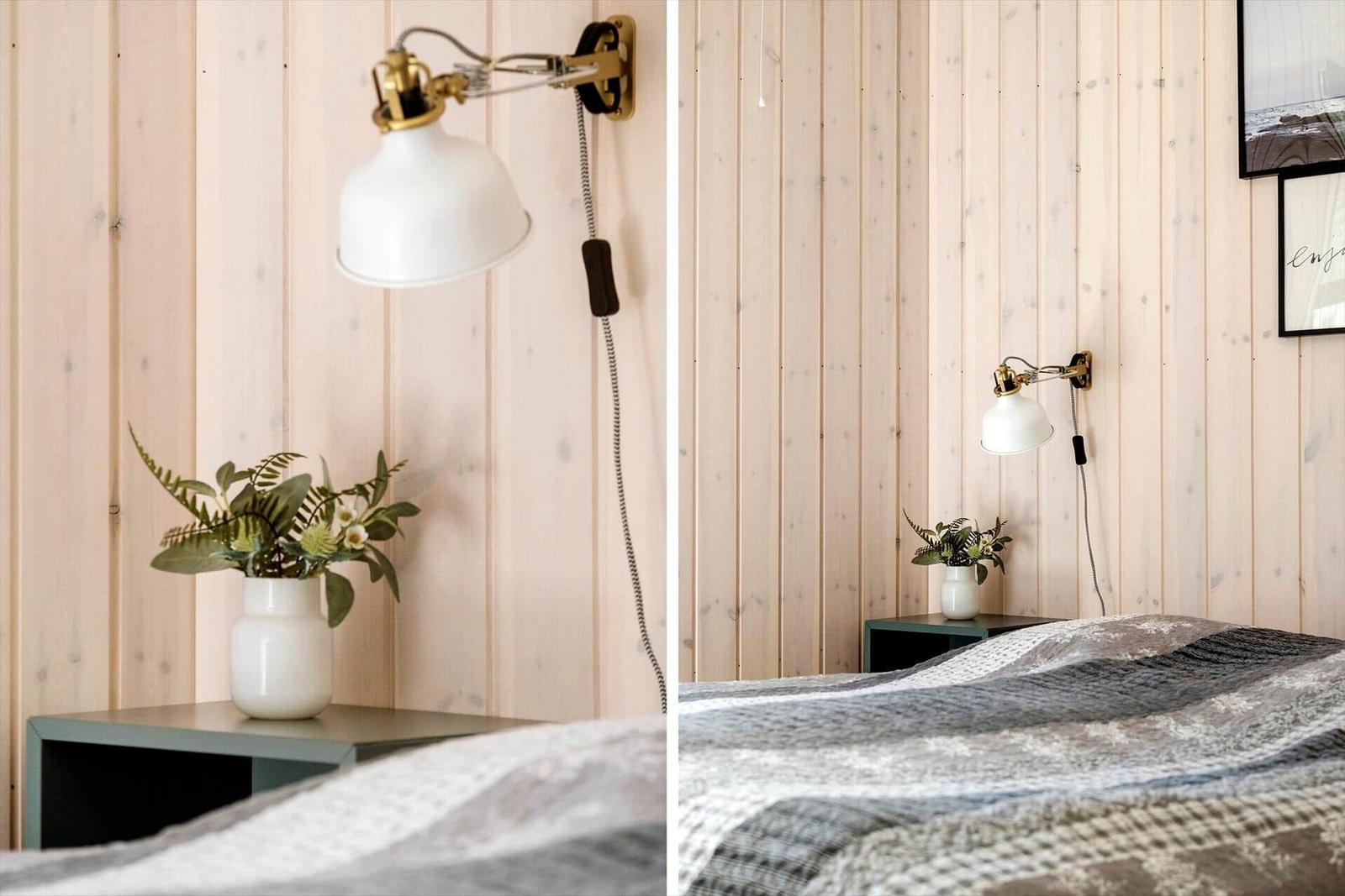 Schlafzimmer mit Holzwand, Wandlampe und Pflanze auf Nachttisch