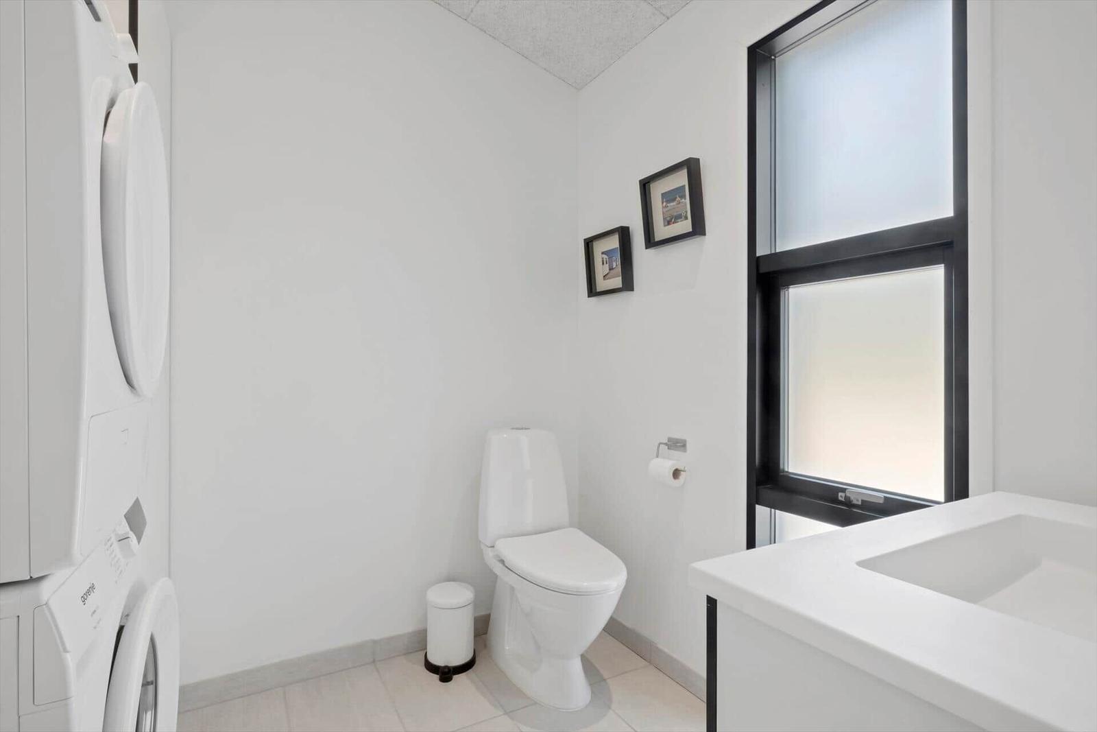 Badezimmer mit Toilette, Waschbecken und Fenster