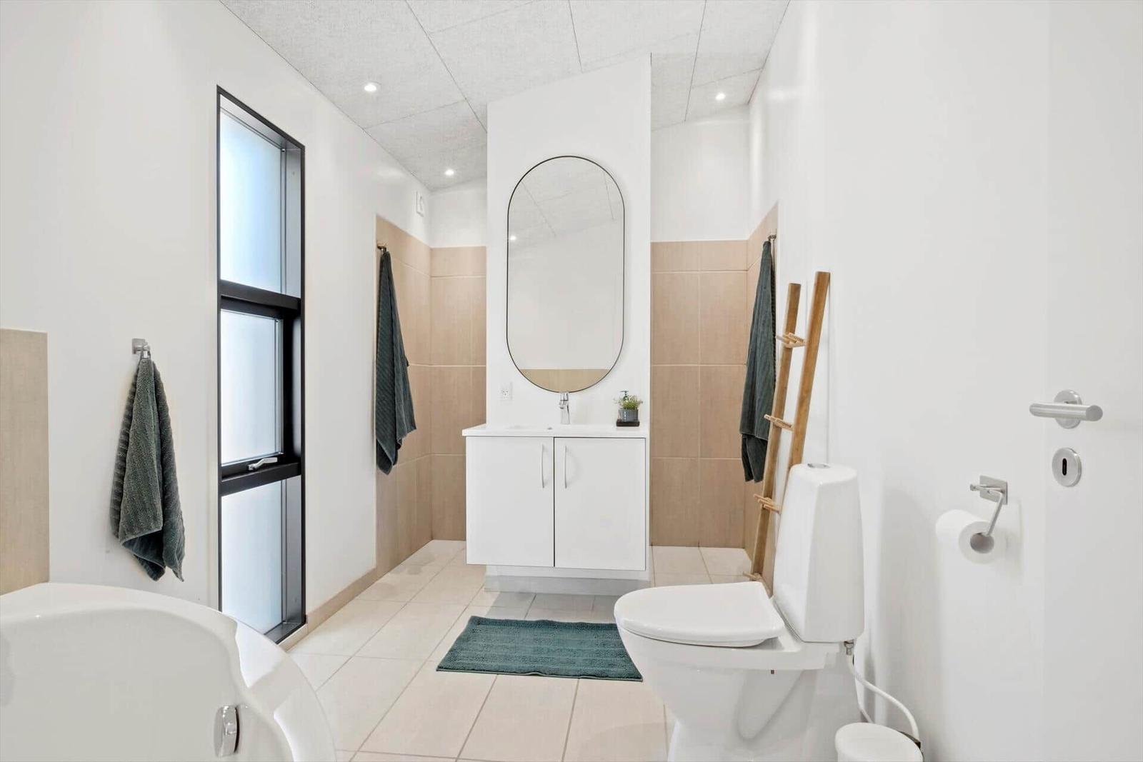 Badezimmer mit Toilette, Waschbecken und Badewanne.