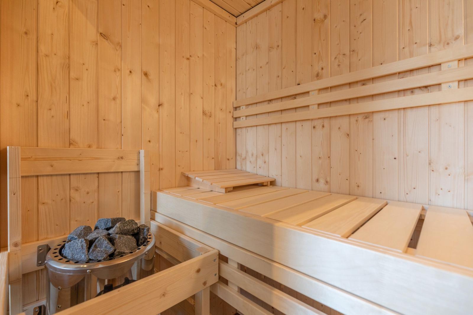 Sauna mit Holzbank und Steinmulde