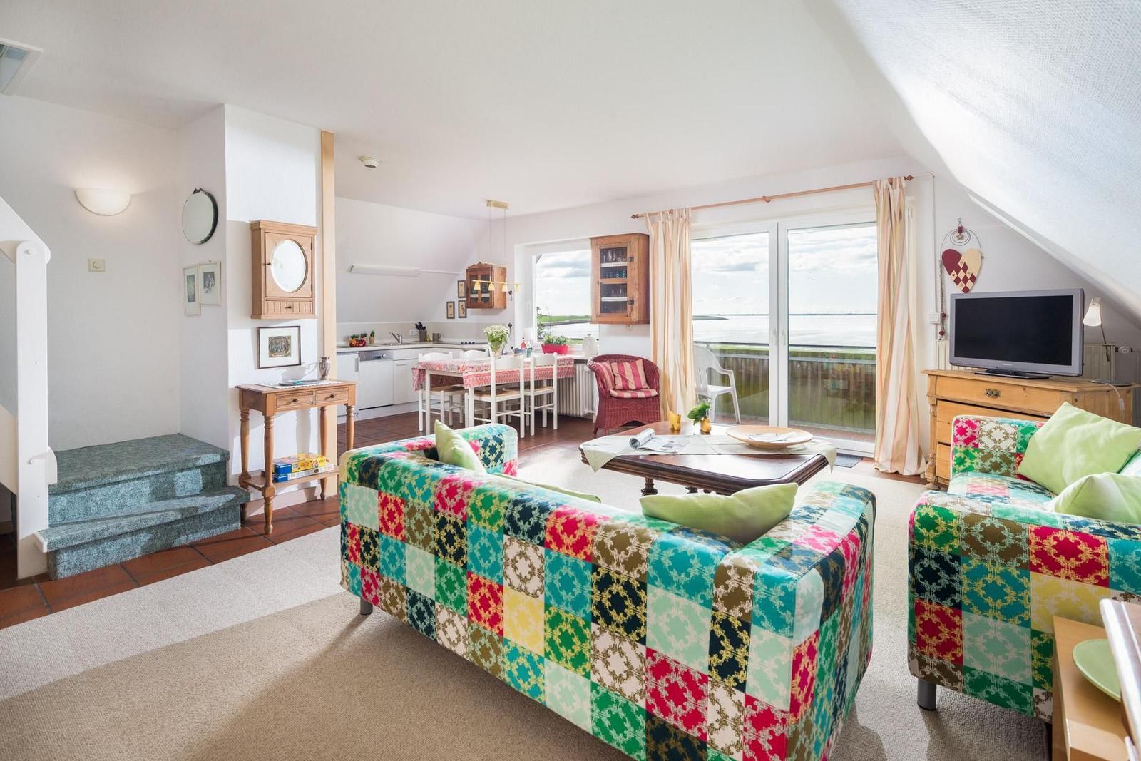 Wohn- und Essbereich mit Balkon und Küche unter Dachschrägen.