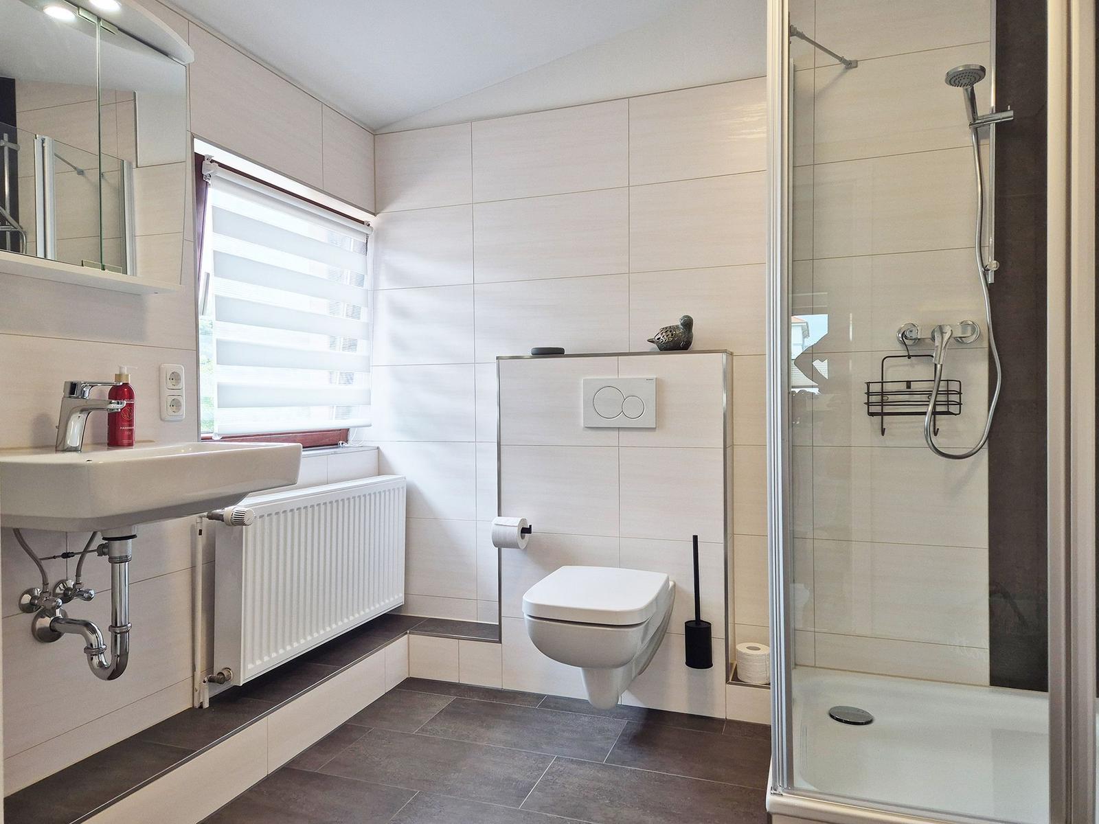 Bathroom with shower, toilet, and sink.