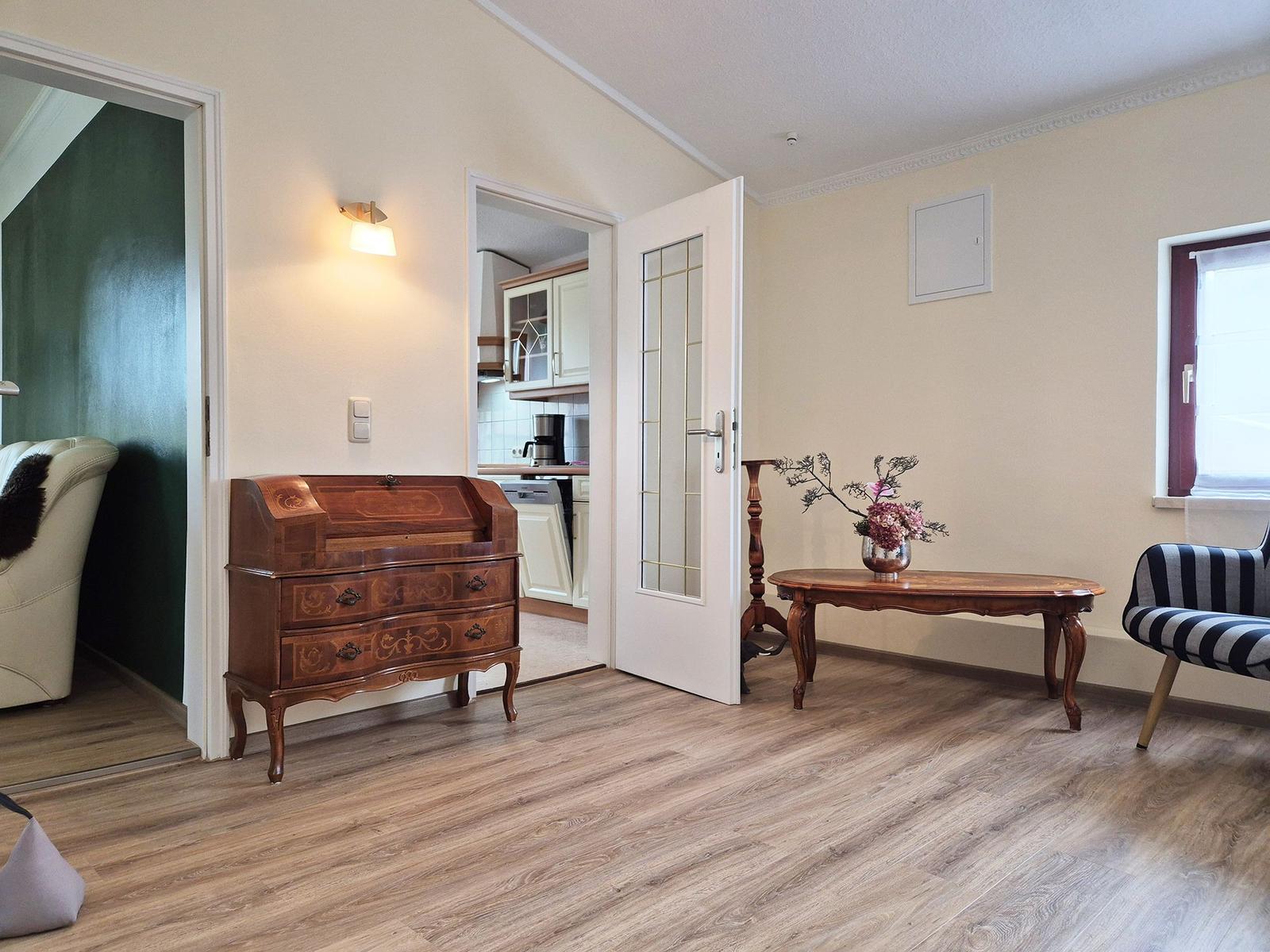 Entrance area with desk, table and chair. Kitchen and bedroom are visible.
