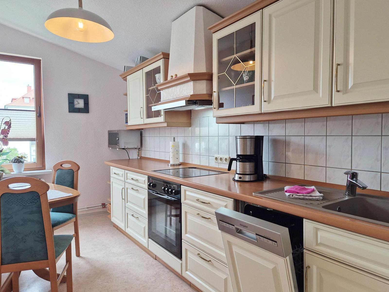 Kitchen with dining area, white cabinets, and wooden countertops.