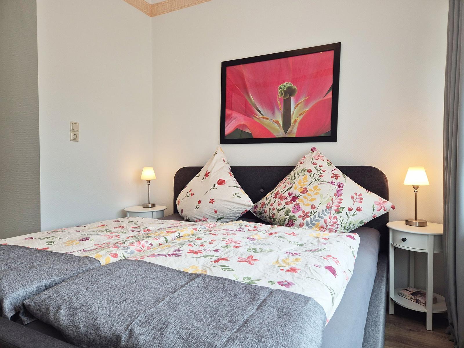 Bedroom with bed, two nightstands, and wall art.