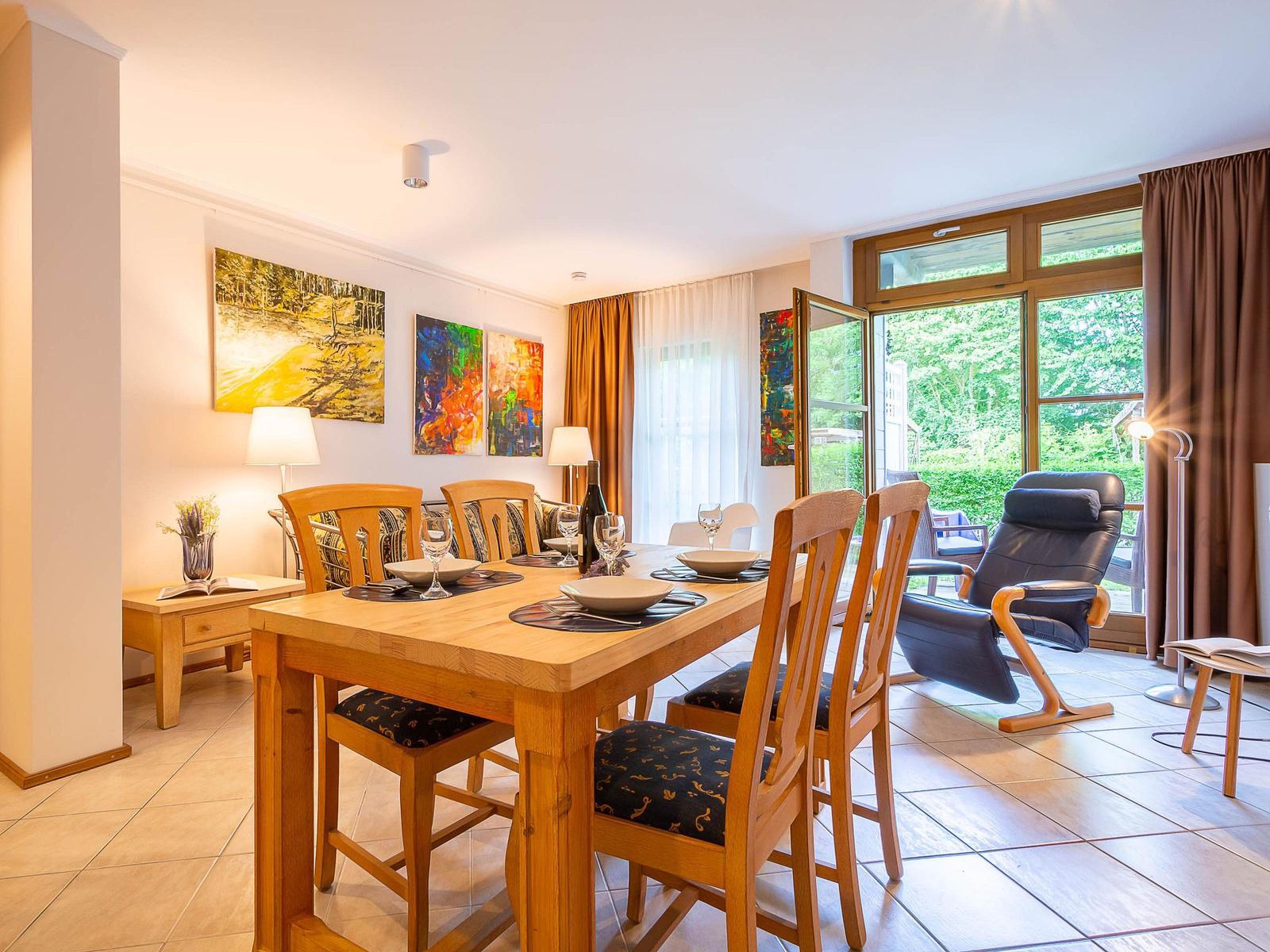 Esszimmer mit Holztisch, Stühlen und Blick auf Garten.