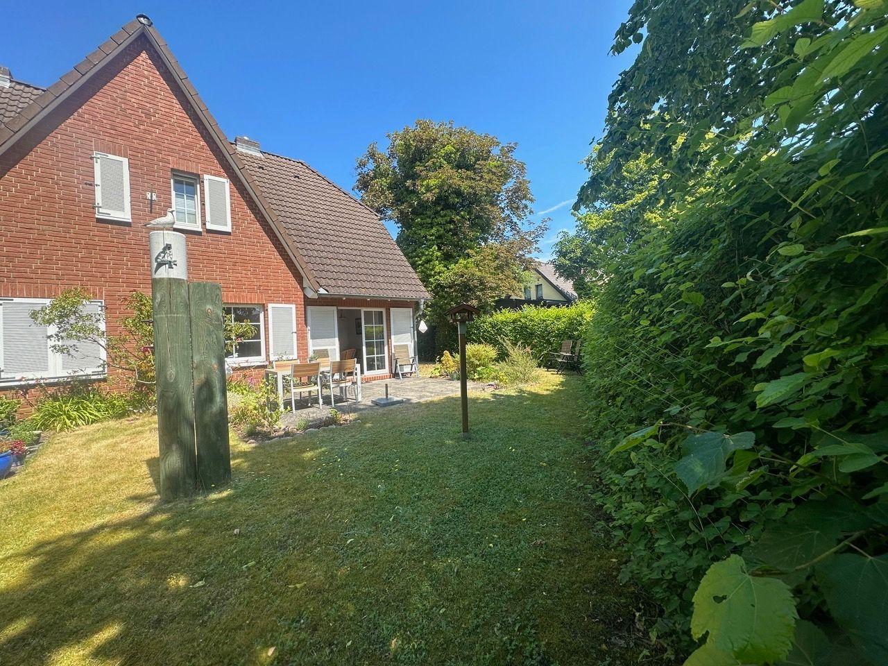 Rotes Backsteingebäude mit Garten und Sitzgelegenheit.