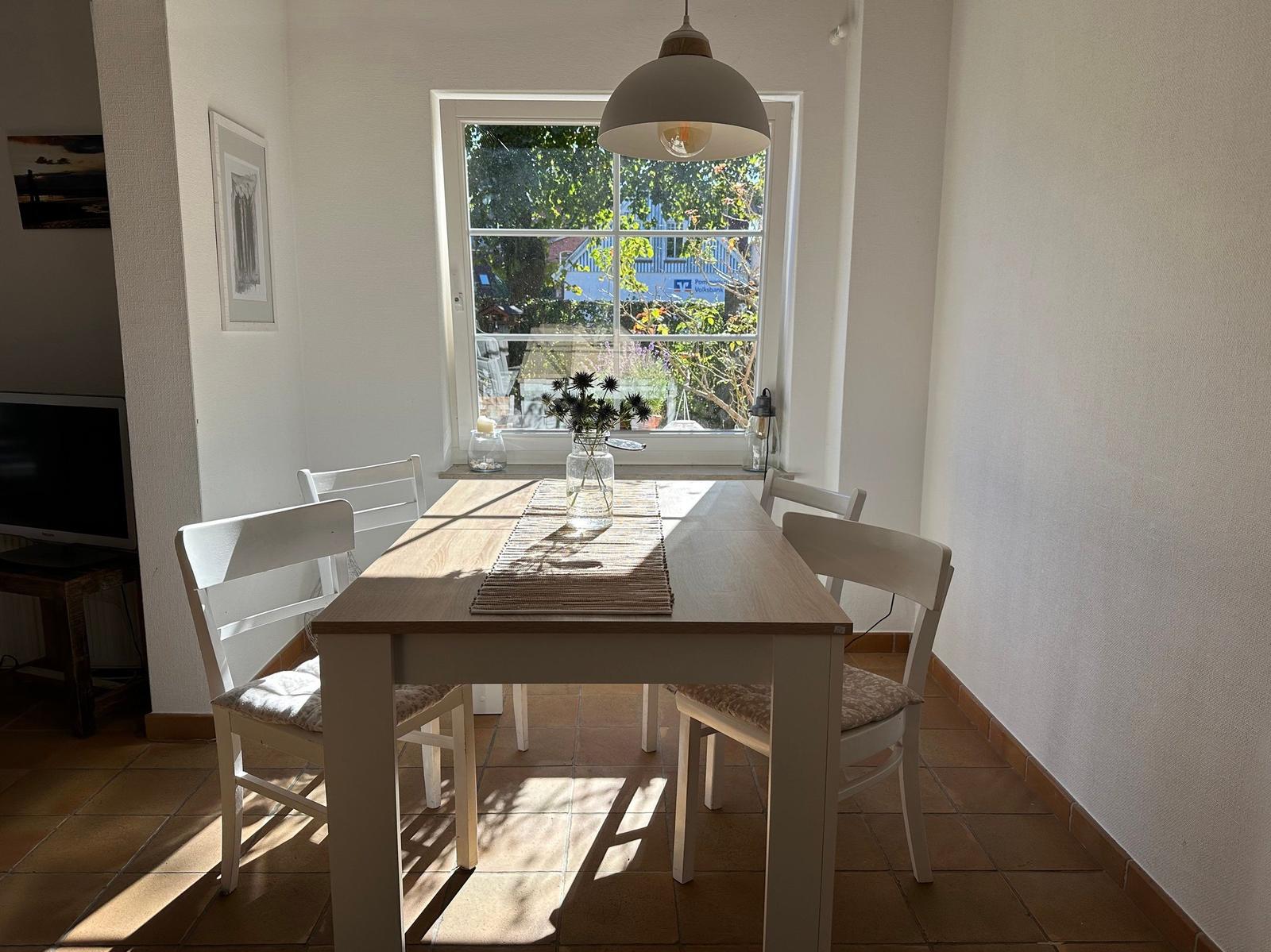 Essbereich mit Tisch, Stühlen und Fensterblick.