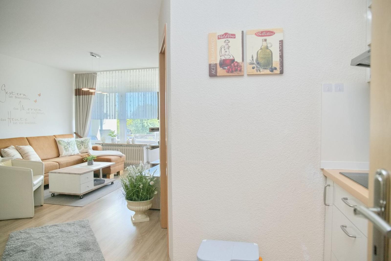 Wohnzimmer mit Sofa und Küche im Hintergrund