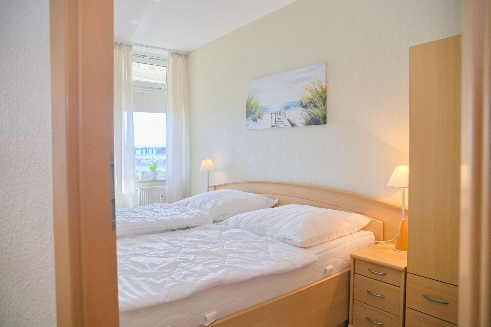 Schlafzimmer mit Bett, Nachttisch und Wandbild