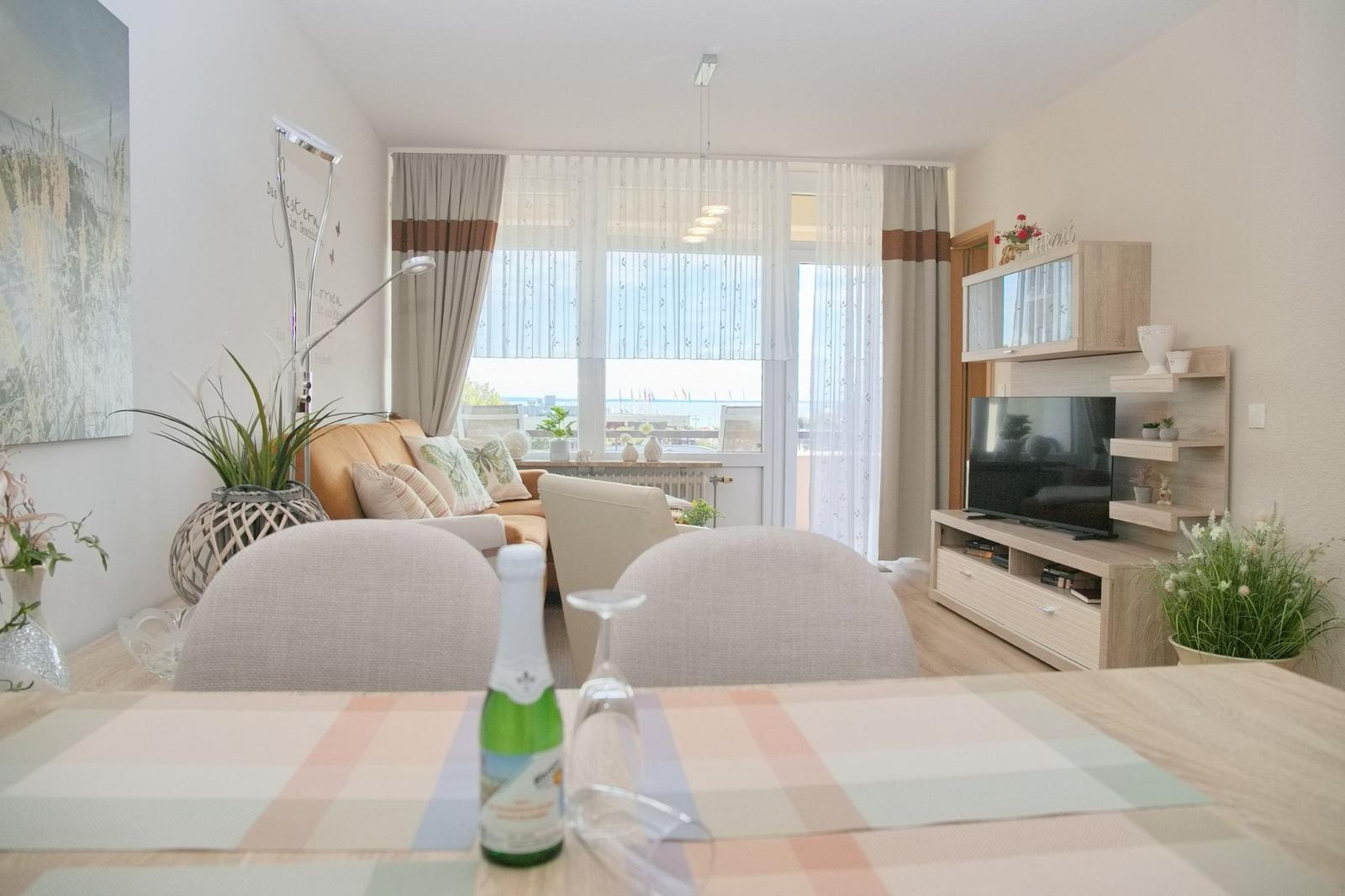 Wohnzimmer mit Essbereich, TV und Blick aufs Meer.