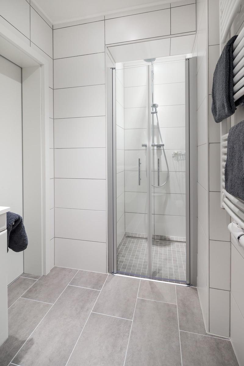 Badezimmer mit Duschkabine, Handtuchhalter und Fliesen