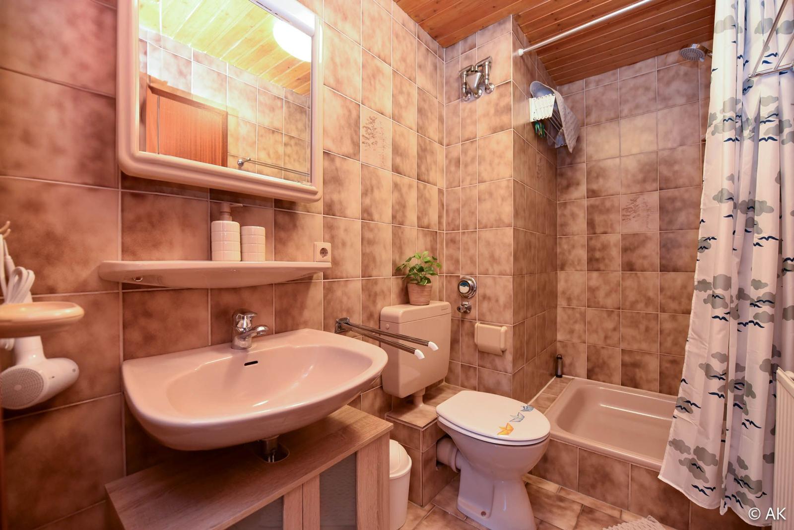 Badezimmer mit Badewanne, Toilette und Waschbecken.