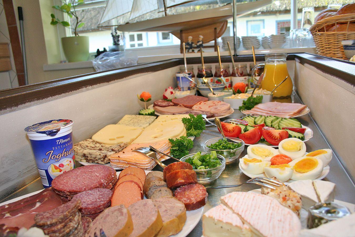 Breakfast table with sausage, cheese, eggs, and vegetables