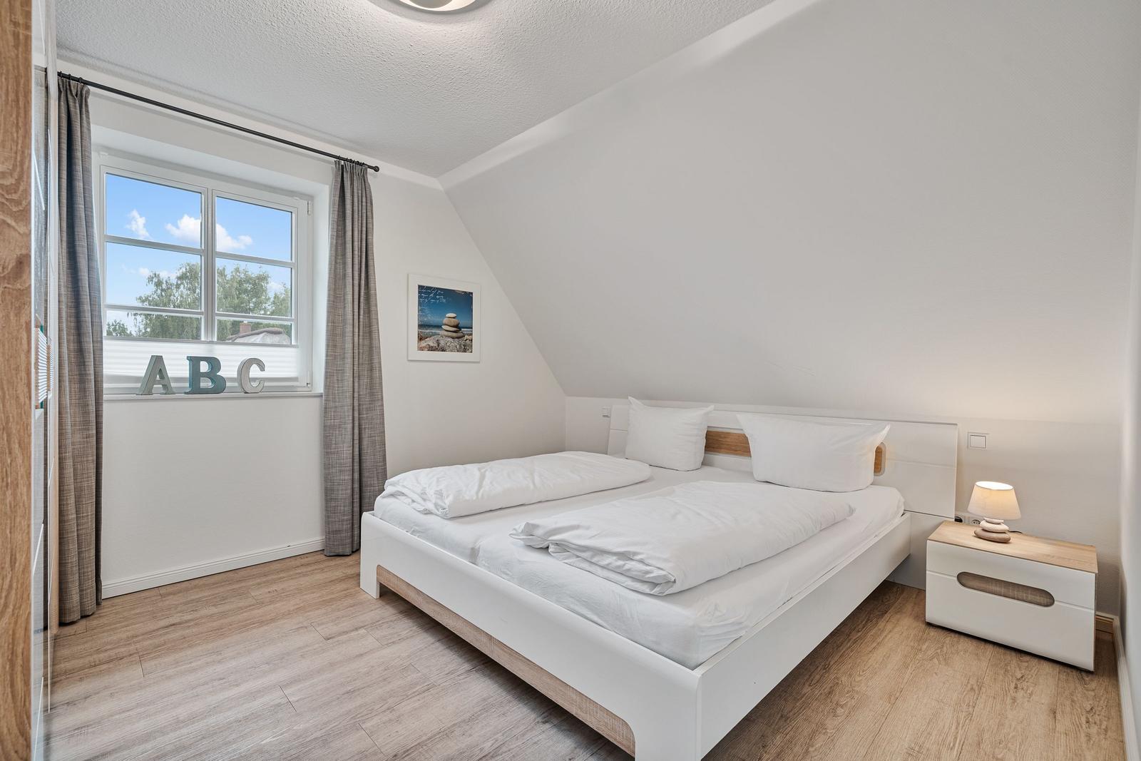 Schlafzimmer mit Doppelbett, Fenster und Nachttisch