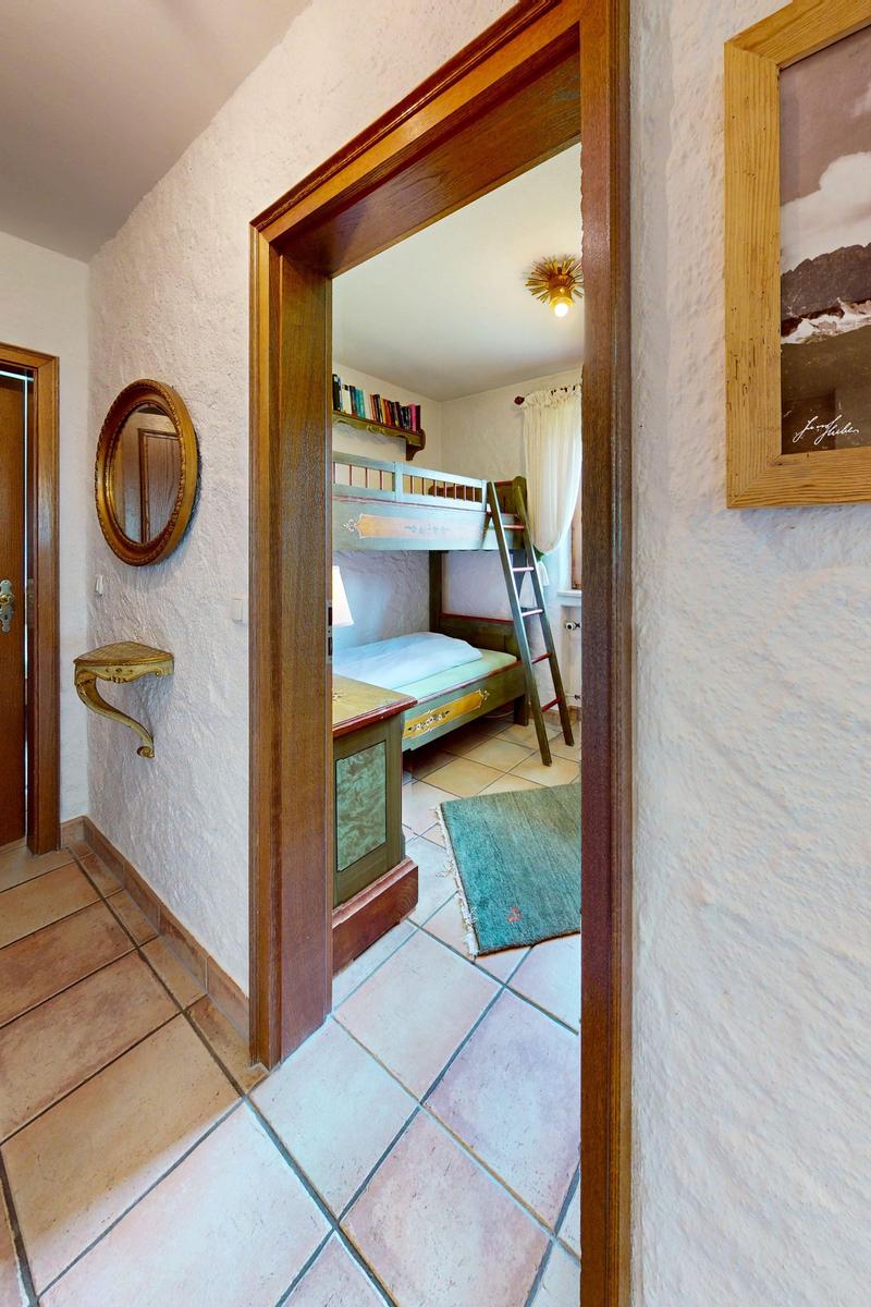 Durchgang in ein Schlafzimmer mit Doppelstockbett und Holzrahmen.