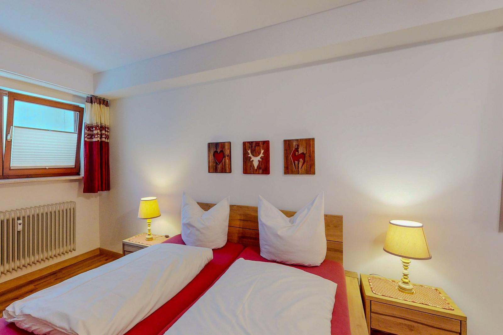 Schlafzimmer mit Doppelbett, zwei Nachttischen und Wanddekoration.