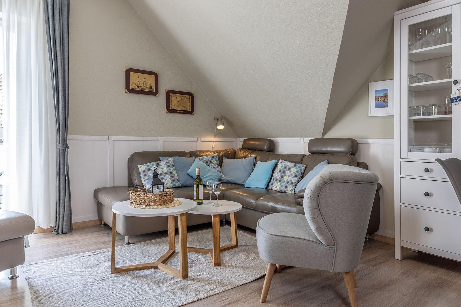 Wohnzimmer mit Sofa, Stuhl und Tisch unter schrägen Decken