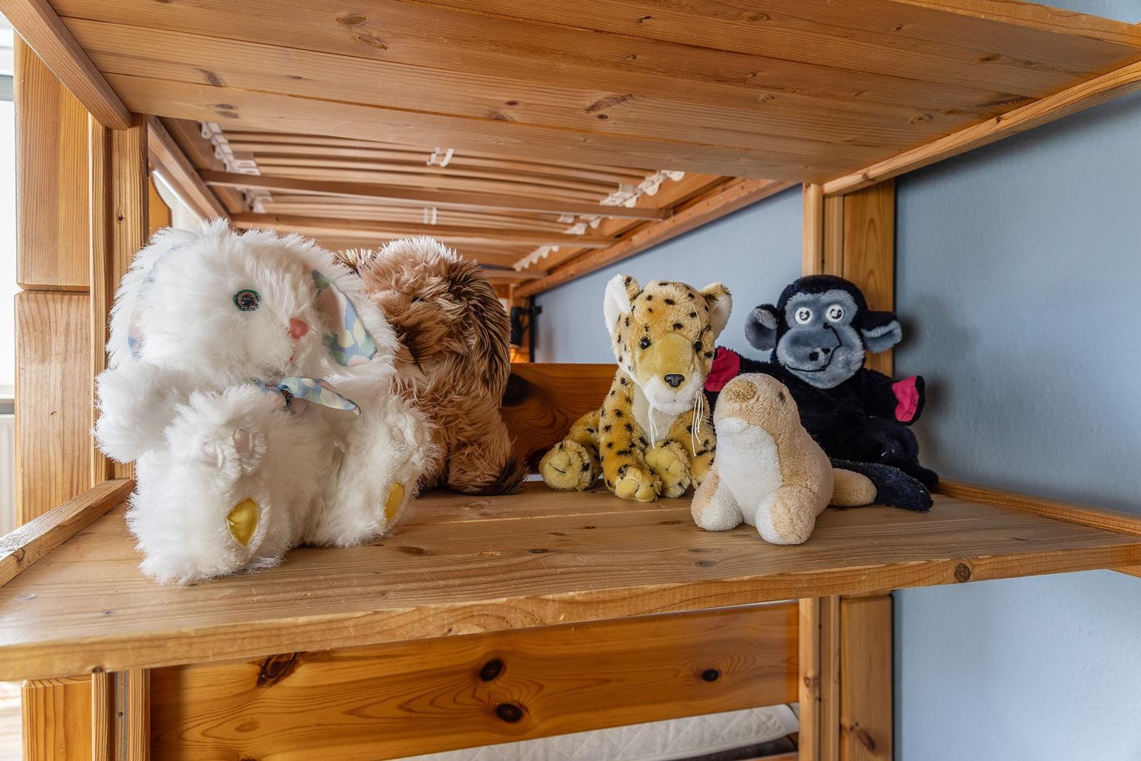 Plüschtiere unter einem Holzbett