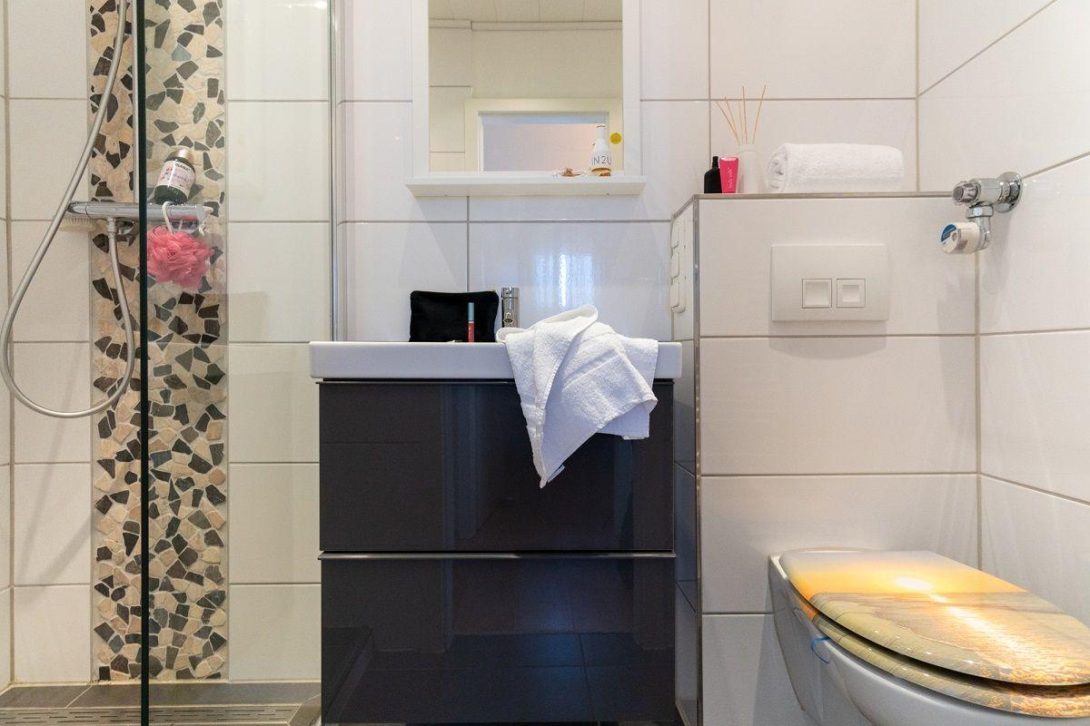 Badezimmer mit Dusche, Waschbecken und Toilette