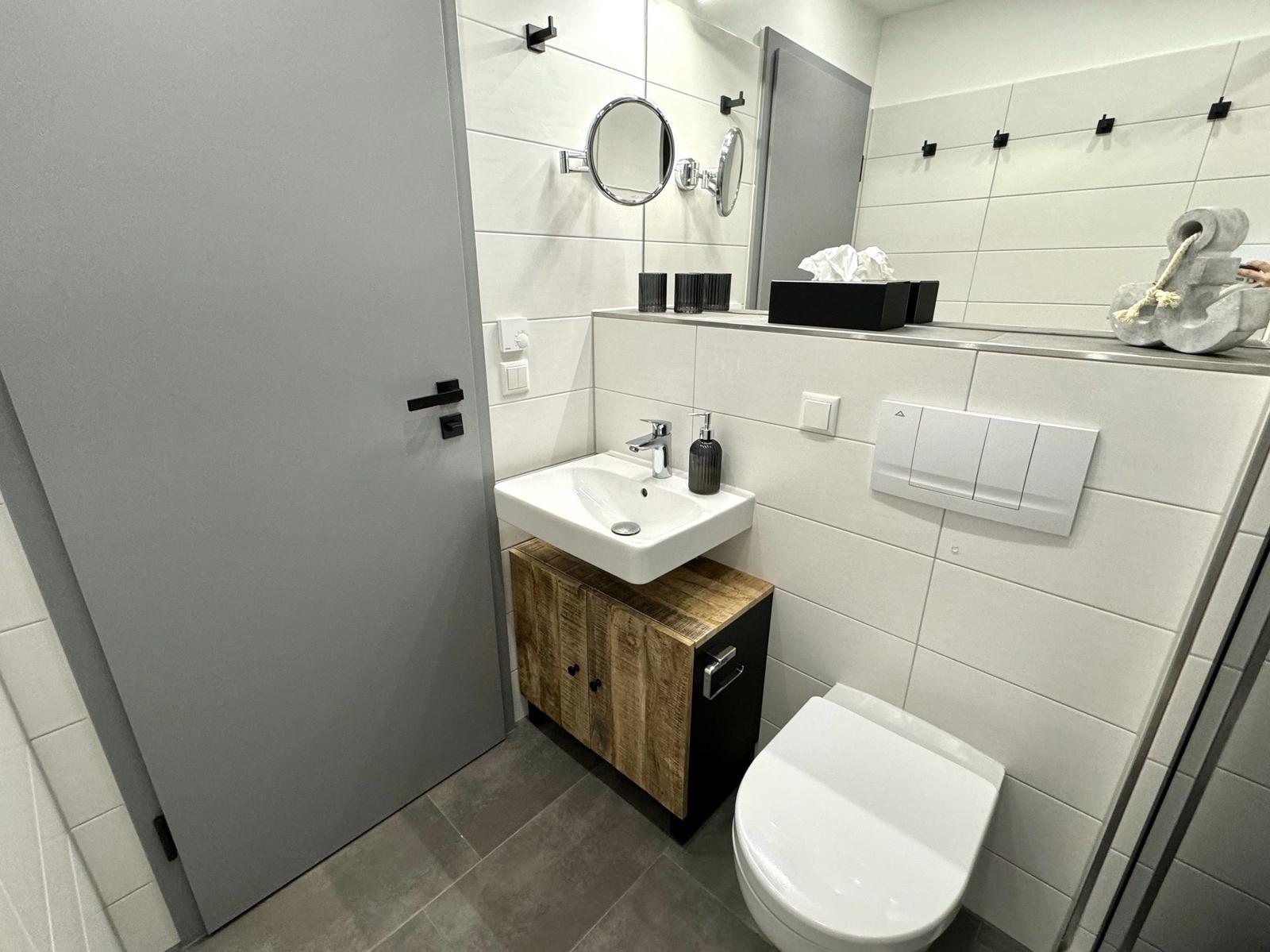 Badezimmer mit Waschbecken, Toilette und Spiegel