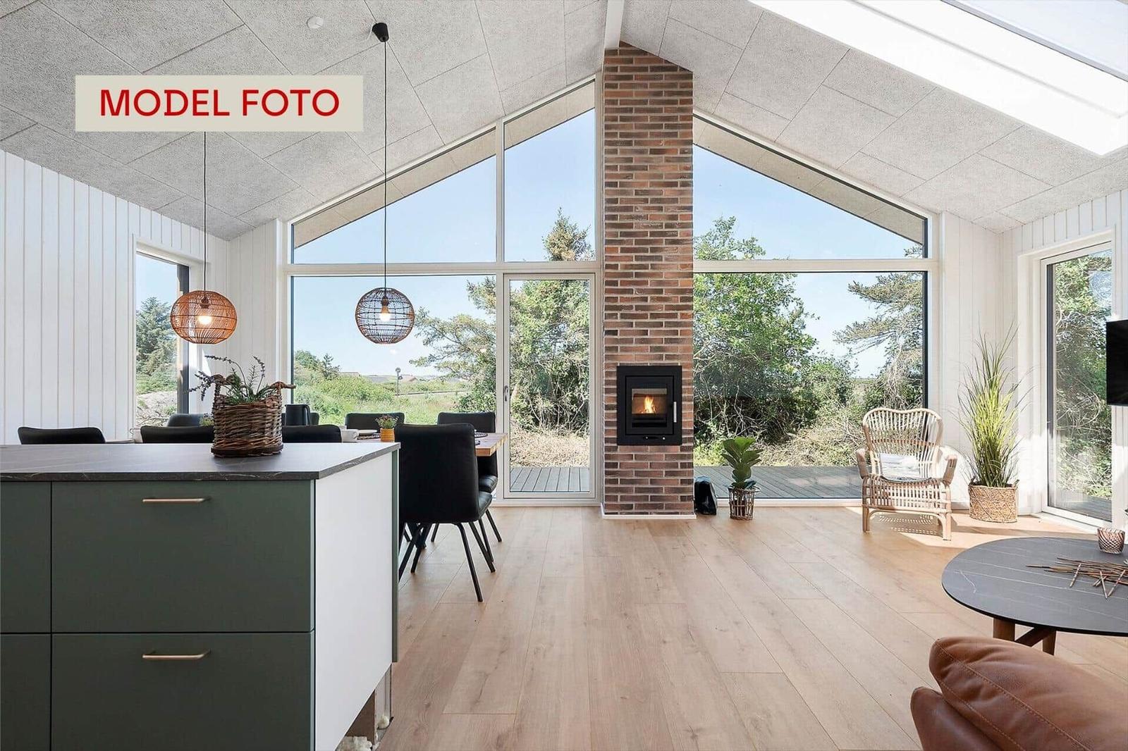 Großes Wohn- und Esszimmer mit Holzboden, großen Fenstern und Kamin.