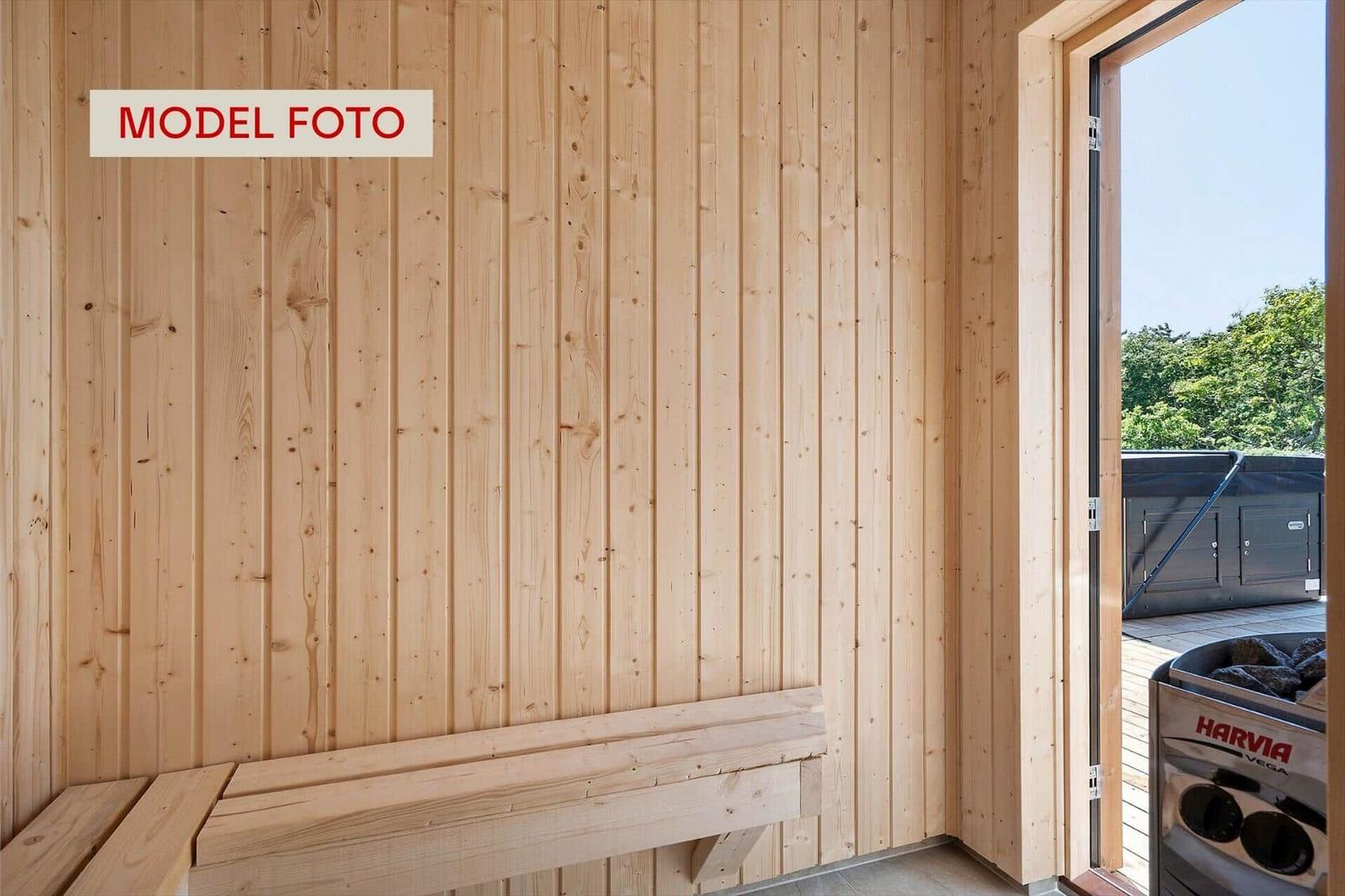 Sauna mit Holzwand und Sitzbank. Durchgang zur Terrasse mit Whirlpool.