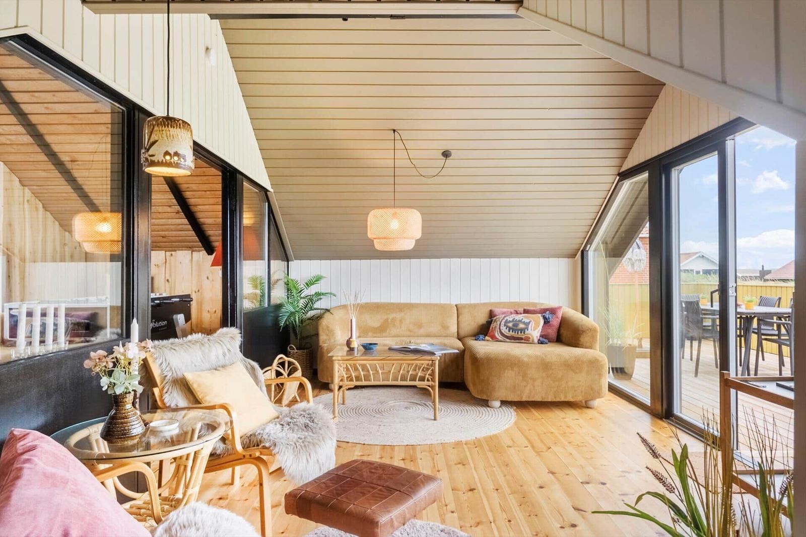 Wohnbereich mit Sofa, Sitzgelegenheiten und Blick auf die Terrasse.