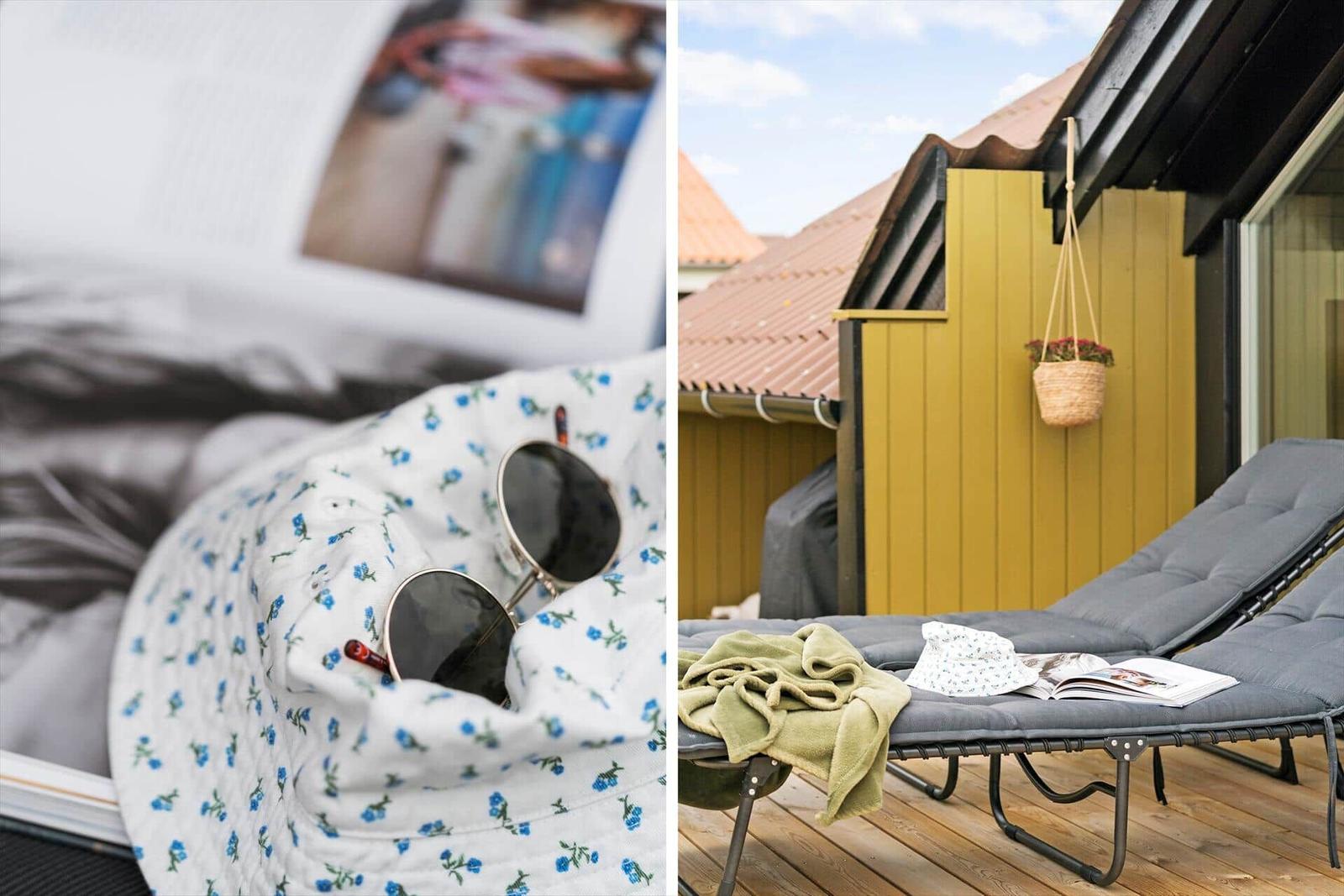 Liegende Sonnenbrille auf blumigem Tuch neben geöffnetem Buch. Außenterrasse mit Liege, Decke und Blumenkorb.