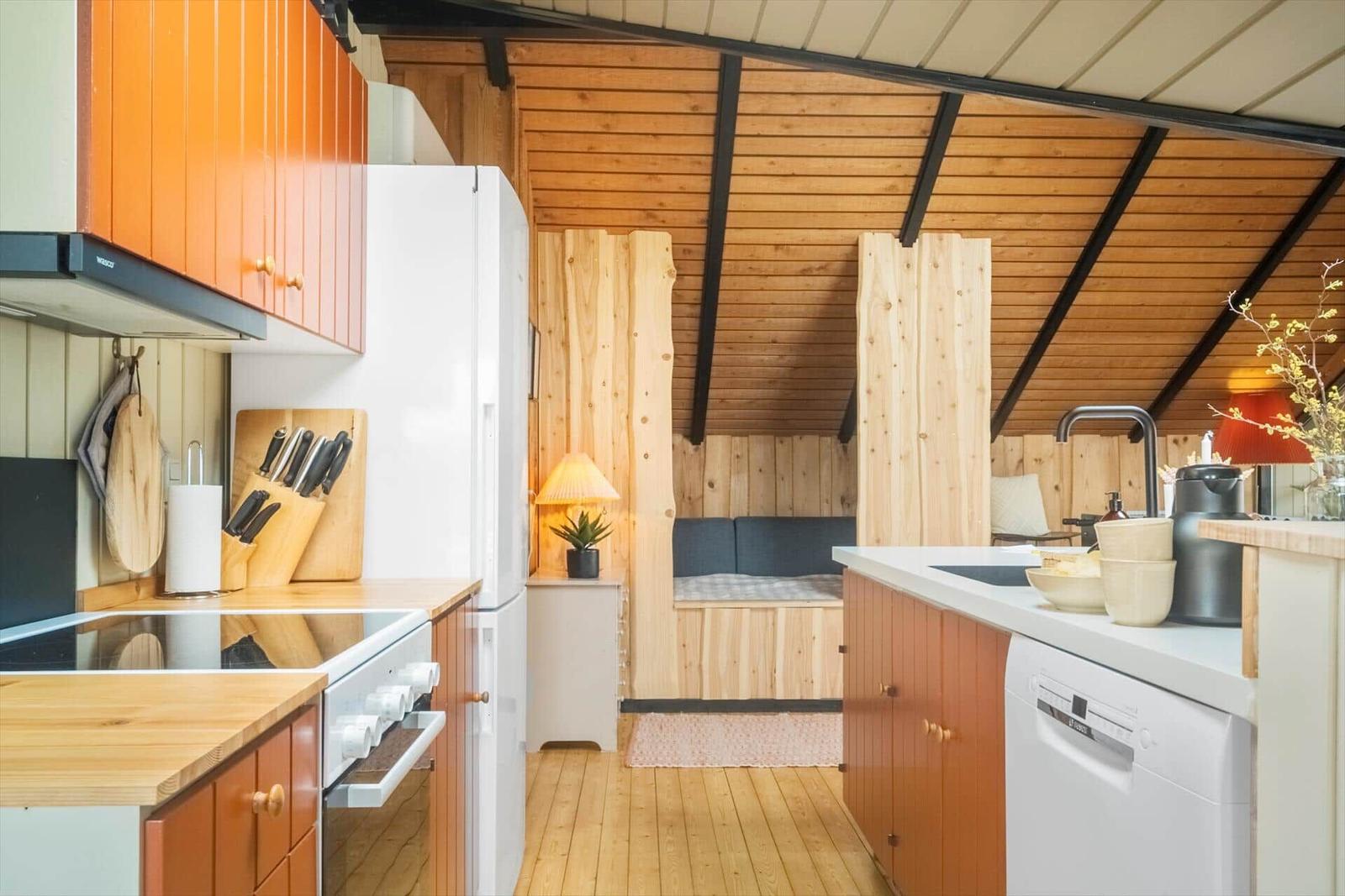 Küche mit Holzoberflächen und integriertem Schlafbereich mit Bett.