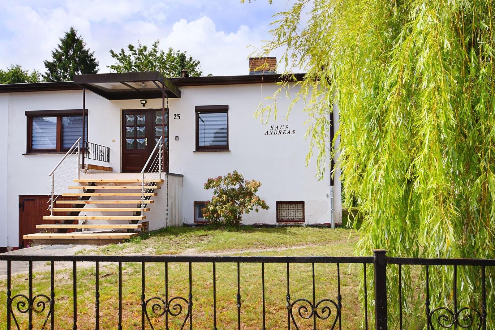 Haus Andreas mit Holztreppe und Schmiedeeisenzaun im Vorgarten.