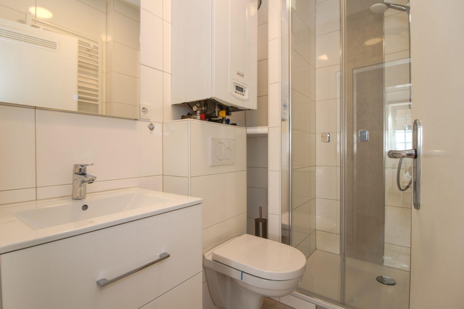 Badezimmer mit Dusche, Waschbecken und Toilette