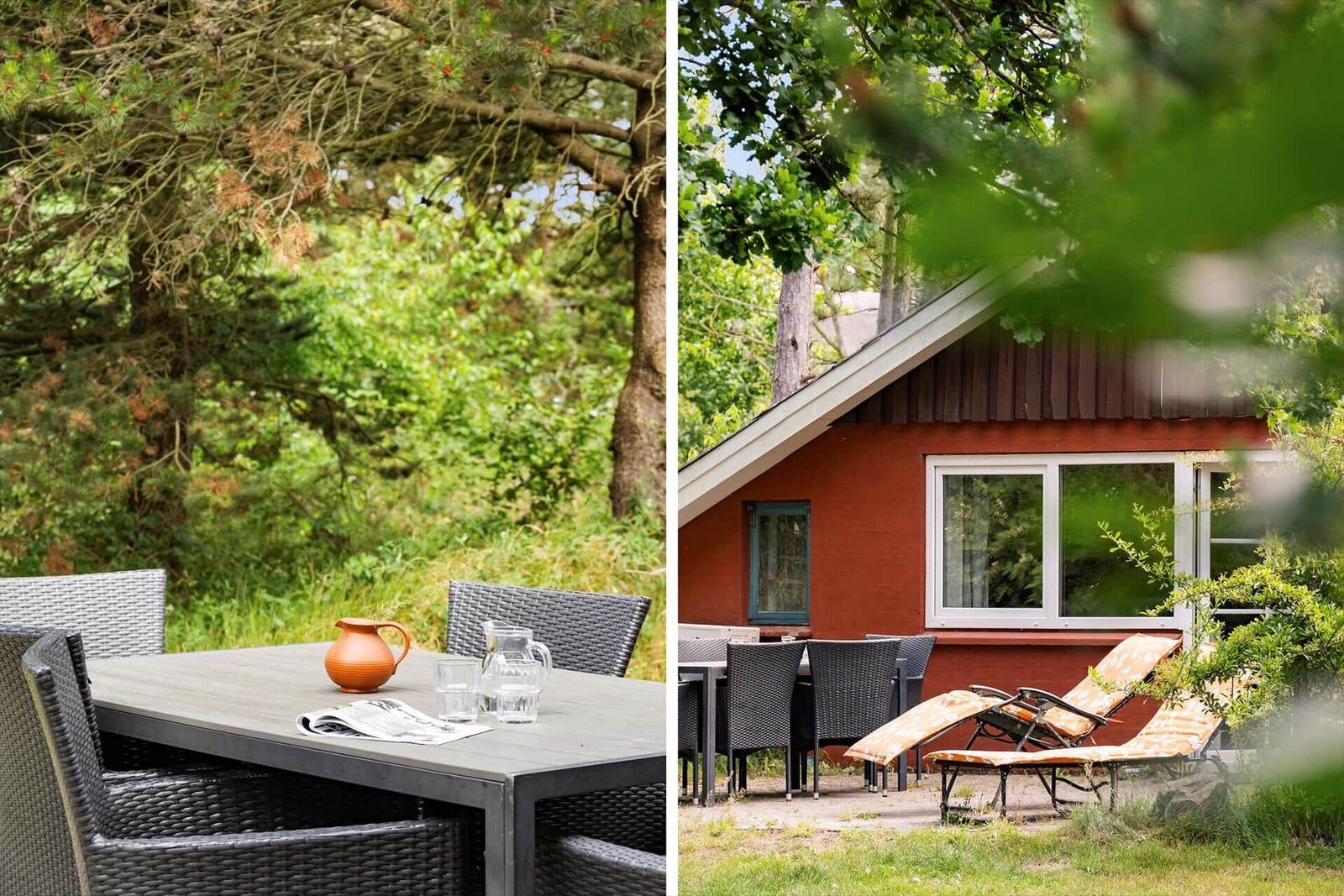 Außenbereich mit Tisch, Stühlen und Liegestühlen neben einem roten Haus.