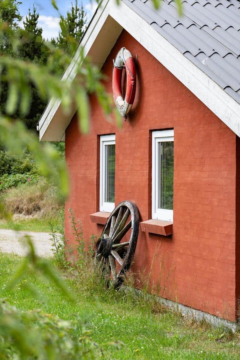 Rotes Haus mit Rettungsring und altem Rad an der Wand
