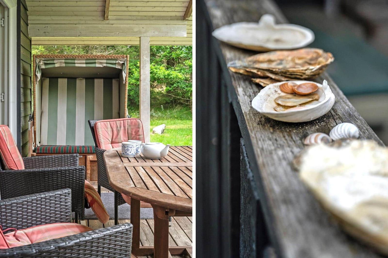 Terrasse mit Tisch, Stühlen und Strandkorb. Holzbank mit Muscheln und Schalentieren.